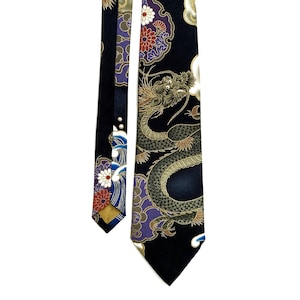 Peut inclure: Une cravate en soie noire avec un motif de dragon dor&eacute; et vert. Le dragon est entour&eacute; de nuages et de fleurs. La cravate est r&eacute;versible et pr&eacute;sente un motif floral de l'autre c&ocirc;t&eacute;.