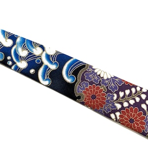 Peut inclure: Une cravate bleue et noire avec un motif floral blanc et or. La cravate pr&eacute;sente un motif de vagues et de fleurs stylis&eacute;es.