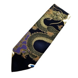 Peut inclure: Une cravate en soie bleu fonc&eacute; avec un motif de dragon dor&eacute; et vert. Le dragon est repr&eacute;sent&eacute; dans une pose tourbillonnante et dynamique, la t&ecirc;te tourn&eacute;e vers le spectateur.