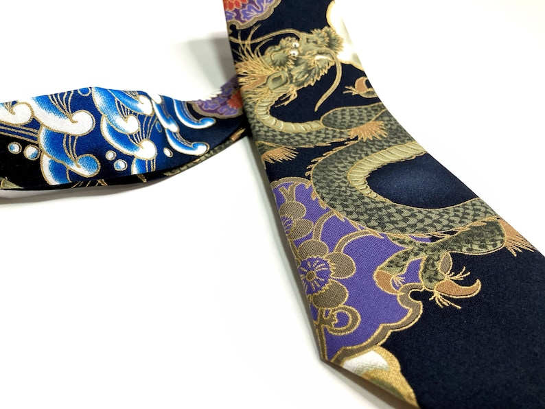 Peut inclure: Une cravate en soie noire avec un motif de dragon dor&eacute; et violet. Le dragon est entour&eacute; de fleurs et de feuilles. La cravate est r&eacute;versible, avec un motif de nuage bleu et blanc de l'autre c&ocirc;t&eacute;.