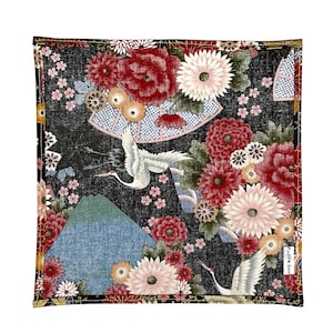 May include: Square fabric with a Japanese-inspired design. The black background is covered with red, pink, and white flowers, cranes, and a mountain. The design includes a fan and small text in the bottom right corner.