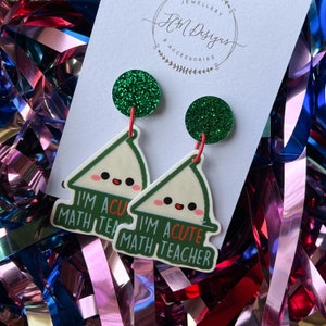May include: A pair of green glitter earrings with a white triangle shape and the text "I'm a cute math teacher".