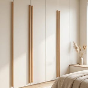 May include: A floor-to-ceiling wall wardrobe featuring smooth, matte off-white panels and long, vertical light-toned wooden handles. The cabinetry spans the entire wall, providing a seamless storage solution with clean lines and a neutral colour palette.