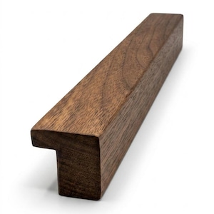 May include: A dark brown wooden drawer pull with a T-shaped end. The rectangular pull has a smooth, polished finish. The design is modern and minimalist, suitable for various furniture styles. The length is approximately 15 cm.