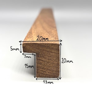 Peut inclure: Un cadre photo en bois avec des dimensions en millimètres. Le cadre est de 20 mm de large, 13 mm de haut et 15 mm de profondeur. Le cadre a un rebord de 7 mm sur le devant.