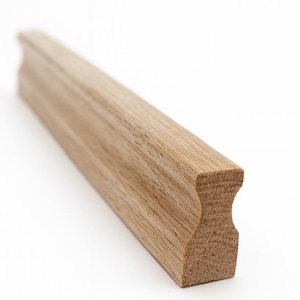 May include: A light brown wooden handrail section with a curved profile. The end of the rail has a decorative, rounded cutout. The wood grain is visible, and the piece is set against a white background. The handrail is likely for a staircase.
