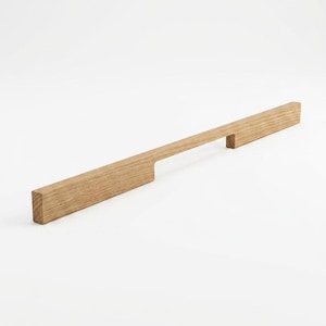 May include: A long, rectangular wooden cabinet pull with a natural finish. The pull features a handle with a cutout and a square end. The wood grain is visible. The pull is designed for a modern aesthetic.