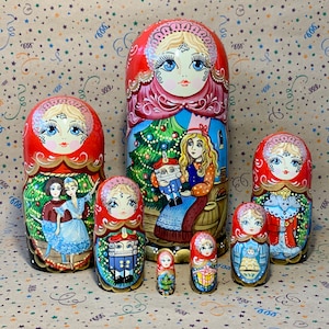 May include: A set of six traditional Russian nesting dolls, or matryoshka dolls, decorated with a Christmas theme. The largest doll is red and features a woman in a pink dress holding a Christmas tree. The other dolls depict a variety of Christmas characters, including a nutcracker, a girl in a blue dress, and a snowman.