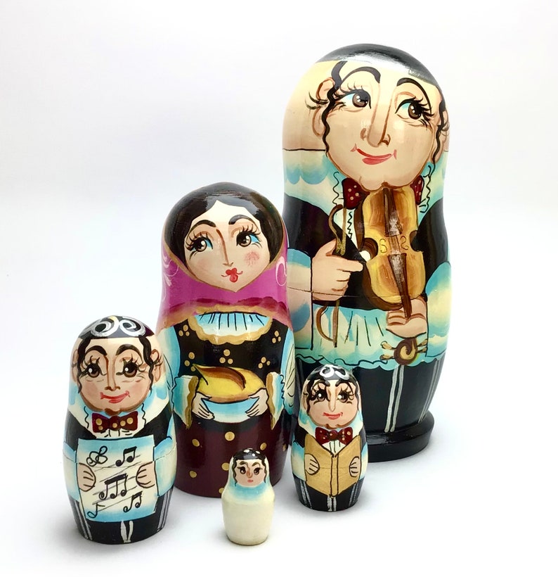 以下が含まれることがあります： 音楽家を描いた、手描きのロシアの入れ子人形、マトリョーシカ人形のセット。 最大の人形はバイオリン奏者を特徴とし、他の人形は楽譜や楽器を持っています。 人形は黒、茶色、クリーム色など、さまざまな色で塗装されています。