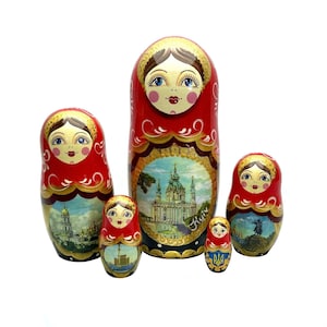 May include: A set of five traditional Russian nesting dolls, or matryoshka dolls. The largest doll is red with a gold trim and a painted image of a church. The other dolls are smaller and feature different designs.