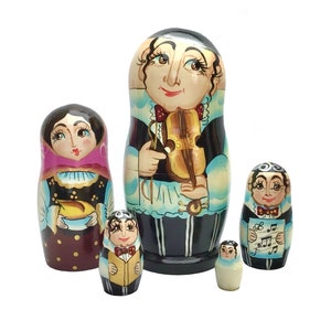 以下が含まれることがあります： 手描きのロシアの入れ子人形、マトリョーシカ人形の5個セット。音楽家を描いています。一番大きい人形はバイオリンを持ち、他は音符や楽器が描かれています。人形は、鮮やかな色使いの伝統的なフォークアートスタイルです。