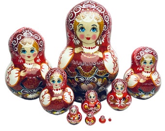 May include: A set of eight red and white Russian nesting dolls, also known as matryoshka dolls. The dolls are painted with traditional floral designs and feature smiling faces. The largest doll is about 10 inches tall and the smallest doll is about 1 inch tall.