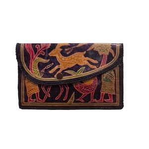 May include: A dark blue leather wallet with a flap closure. The wallet features a detailed, colourful design of a deer, figures, and floral elements. The edges are stitched, and the wallet is secured with a button.