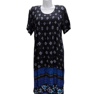 Könnte beinhalten: Schwarzes Kleid mit Rundhalsausschnitt und kurzen Ärmeln. Das Kleid hat ein sich wiederholendes weißes und blaues Blumenmuster auf der Oberseite und einen blau-schwarzen gemusterten Saum. Das Kleid wird auf einer weißen Schaufensterpuppe präsentiert.