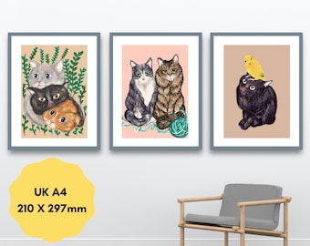 May include: Three framed art prints featuring cat illustrations. The first shows three cats among green vines. The second depicts two cats with a ball of yarn on a pink background. The third shows a black cat with a yellow bird. Text reads UK A4 210 X 297mm.