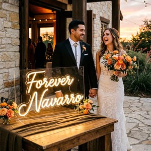 May include: A wedding scene with a smiling couple near a wooden table. A neon sign reading "Forever Navarro" glows in warm white. The table is decorated with flowers and a dark brown cloth. The sign is 91 cm wide.