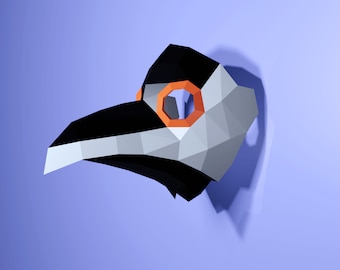 May include: A white and black origami mask with an orange eye hole. The mask is shaped like a bird's head.