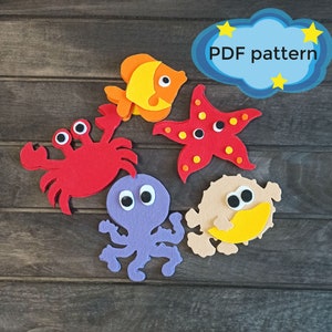 May include: A set of five felt sea creature shapes, including a red crab, a purple octopus, a yellow and orange fish, a red starfish, and a tan pufferfish. Each creature has googly eyes and is ready to be used for a craft project. PDF pattern.