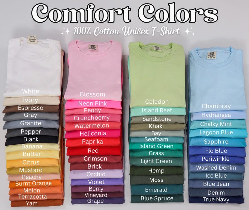 Pode incluir: Pilhas de camisetas unissex Comfort Colors 100% algod&atilde;o dobradas em v&aacute;rias cores, incluindo branco, rosa, verde e azul. Cada pilha exibe um nome de cor diferente, como "Blossom", "Celedon" e "Chambray".