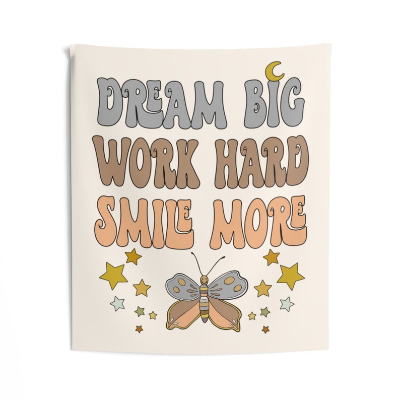 May include: A beige tapestry with the text "Dream Big Work Hard Smile More" in a retro font. The tapestry features a butterfly with orange, yellow, and gray wings and a crescent moon.