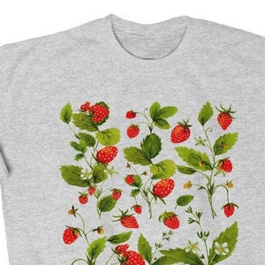 Puede incluir: Una sudadera gris claro con un dise&ntilde;o bot&aacute;nico de fresas. El dise&ntilde;o incluye fresas rojas, hojas verdes y peque&ntilde;as flores blancas. Las fresas est&aacute;n en varias etapas de madurez.