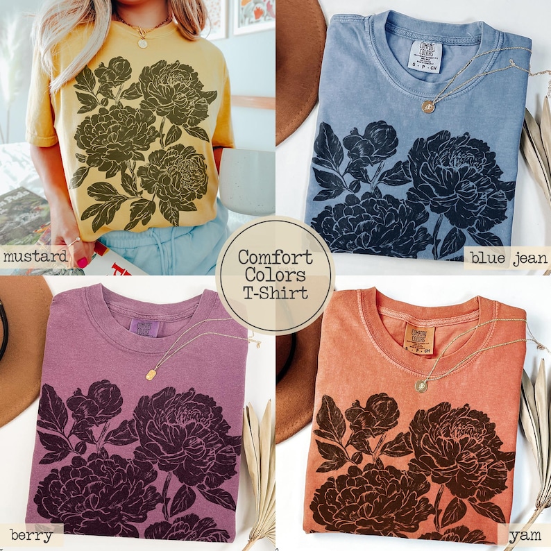 Puede incluir: Cuatro camisetas Comfort Colors en colores mostaza, azul jean, baya y &ntilde;ame. Cada camiseta de manga corta presenta un gr&aacute;fico floral oscuro y detallado de peon&iacute;as en la parte delantera. Las camisetas tienen cuello redondo y un corte relajado.