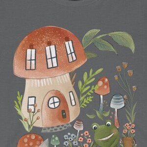 K&ouml;nnte beinhalten: Eine fantasievolle Illustration eines Pilzhauses mit drei Fenstern, umgeben von gr&uuml;nem Laub, Blumen und Pilzen. Ein l&auml;chelnder gr&uuml;ner Frosch sitzt in der N&auml;he des Hauses und h&auml;lt einen kleinen Topf.