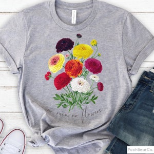 May include: Gray t-shirt with a floral design featuring a bouquet of colorful ranunculus flowers. The text "no rain, no flowers" is printed below the flowers.