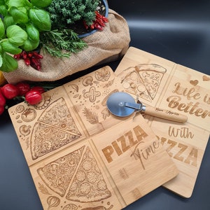 Può includere: Due taglieri in legno per pizza con fette di pizza incise, erbe e il testo "Pizza Time" e "Life is Better with Pizza". Un tagliere include un taglia pizza.