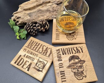 May include: Three wooden coasters with different designs. The first coaster says "Whisky is always a good idea" and has a glass of whiskey with ice cubes. The second coaster says "Time to drink whisky" and has a skull wearing a hat and smoking a cigar. The third coaster says "Time to drink whisky" and has a skull wearing a hat and smoking a cigar. A glass of whiskey is sitting on the second coaster.