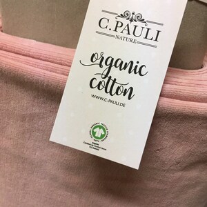 May include: A pink organic cotton fabric swatch with a white label that reads "C. PAULI - NATURE - organic cotton www.c-pauli.de" and a green GOTS (Global Organic Textile Standard) certification logo.