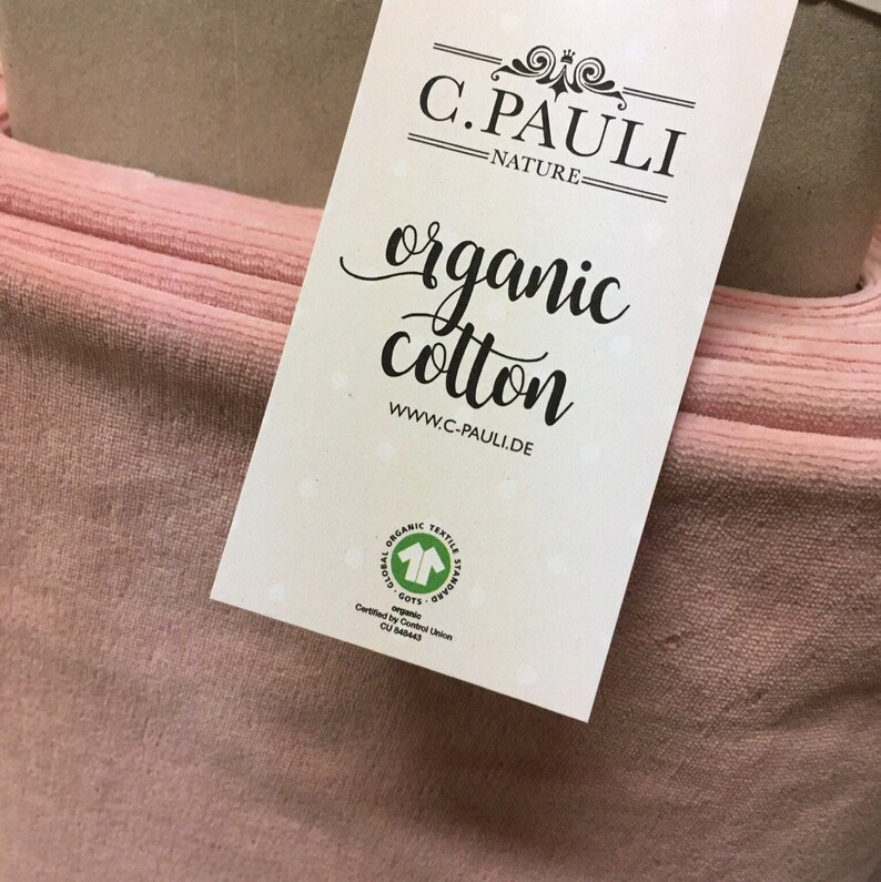 May include: A pink organic cotton fabric swatch with a white label that reads "C. PAULI - NATURE - organic cotton www.c-pauli.de" and a green GOTS (Global Organic Textile Standard) certification logo.