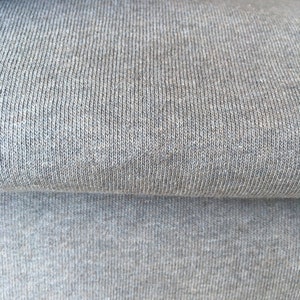 May include: Close-up of a gray knitted fabric with a textured surface.