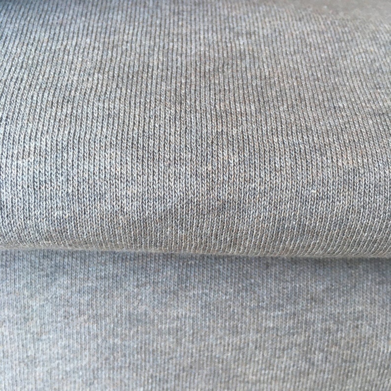 May include: Close-up of a gray knitted fabric with a textured surface.