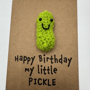 May include: A brown card with a green crocheted pickle with a smiling face. The card says "Happy Birthday my little PICKLE".