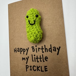 May include: A brown card with a green crocheted pickle with a smiling face. The card says "Happy Birthday my little PICKLE".
