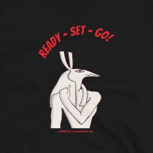 May include: Black t-shirt with a white illustration of a creature with a bird head and human body. The text "READY - SET - GO!" is printed in red above the illustration.