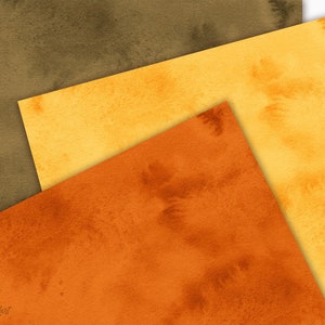 Puede incluir: Tres hojas de papel superpuestas en tonos de marr&oacute;n, amarillo y naranja. El papel tiene una textura de acuarela y un aspecto descolorido y vintage.