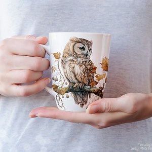 May include: A white ceramic mug with a brown and white owl illustration. The owl is perched on a branch with leaves and berries. The mug is a great gift for nature lovers.