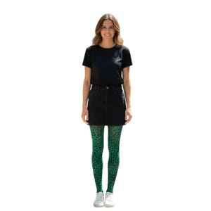 A woman standing, wearing a white t-shirt, black mini skirt, black high heels, and Emerald Green coloured leopard print patterned tights.