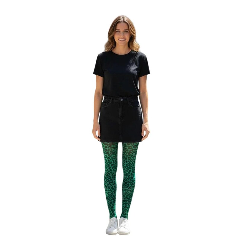 A woman standing, wearing a white t-shirt, black mini skirt, black high heels, and Emerald Green coloured leopard print patterned tights.