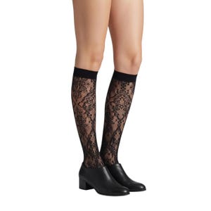 Puede incluir: Un par de calcetines negros hasta la rodilla de encaje con un intrincado patrón floral y una banda negra sólida en la parte superior. Los calcetines se combinan con zapatos de cuero negro con punta redondeada y tacón bajo de bloque.