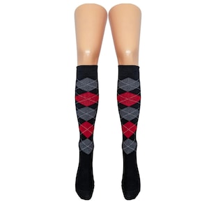 May include: Knee-high socks with a black base, showcasing a repeating argyle pattern in red and grey diamonds. The socks are displayed on a mannequin leg.