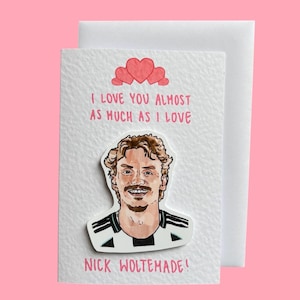 Puede incluir: Una tarjeta de felicitación blanca con un dibujo de un hombre con una camisa a rayas blancas y negras. La tarjeta tiene el texto "I LOVE YOU ALMOST AS MUCH AS I LOVE" y "NICK WOLTEMADE!" con tres corazones rosas encima.