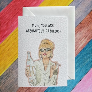 May include: Greeting card with the text "MUM, YOU ARE ABSOLUTELY FABULOUS!" features an illustration of a woman in sunglasses holding a bottle and cigarette. The card is paired with a white envelope.