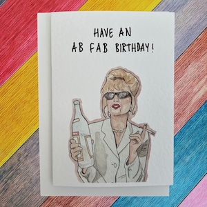 Puede incluir: Tarjeta de felicitación de cumpleaños con el texto "HAVE AN AB FAB BIRTHDAY!". La ilustración muestra a una mujer con gafas de sol sosteniendo una botella y un cigarrillo. La tarjeta está sobre un fondo blanco.