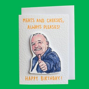 May include: A white textured greeting card featuring a hand-drawn illustration of a person in a blue shirt giving a thumbs up. The text reads MEATS AND CHEESES, ALWAYS PLEASES! at the top and HAPPY BIRTHDAY! at the bottom in orange lettering.