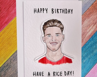 Può includere: Un biglietto bianco con il testo "Happy Birthday" e un disegno di un uomo con i capelli castani. Il testo "Have a Rice Day!" è in fondo al biglietto.