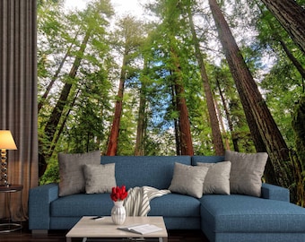 May include: A blue sectional sofa with gray throw pillows and a white and gray striped throw blanket. A coffee table with a vase of red flowers and a forest mural backdrop creates a nature-inspired living room.
