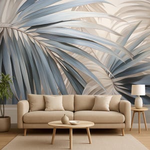 May include: A living room scene featuring a beige sofa with several pillows, a round wooden coffee table, and a side table with a lamp. The backdrop is a large mural of blue and beige palm leaves, creating a serene and natural ambiance.